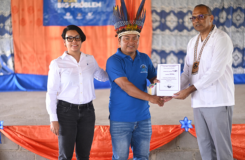 Aishalton Village Council representative receives the contract document from Health Minister, Dr. Frank Anthony, in the presence of Minister within the Ministry of Housing and Water, Susan Rodrigues