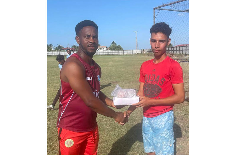 Representative of the project, Seon Hetmyer (left), presenting the balls to Ahil Hemraj of RHCCCC.