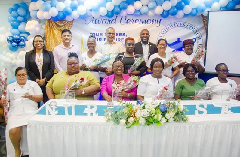 Senior health officials pose with the nurses who were awarded for 30 or more years of service