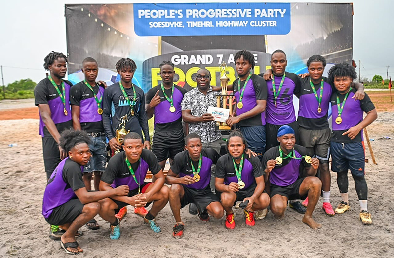 Kuru Kururu ‘A’ Captain, Shervin Henry receives the top prize and trophy from Hon. Minister Kwame McCoy in the presence of his teammate on Sunday afternoon at the Kuru Kuru Ground