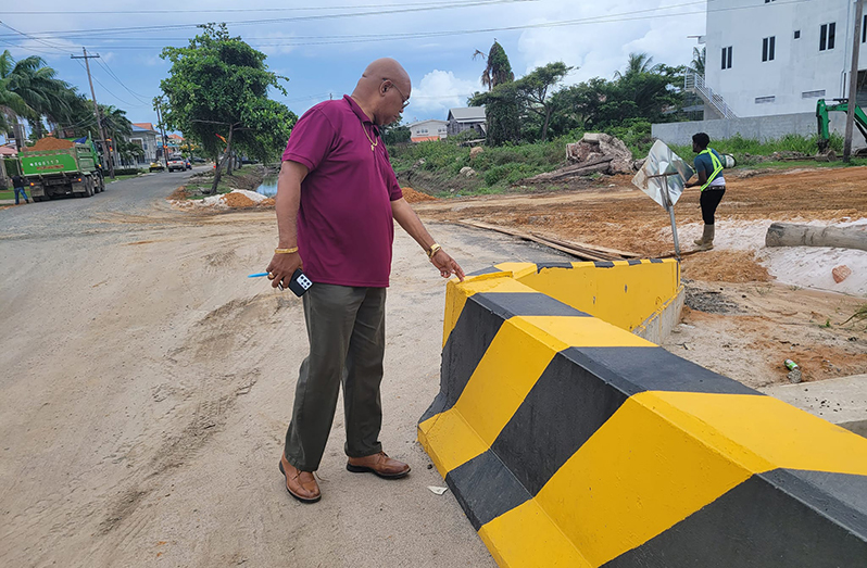 Minister Edghill assessing the remedial works done so far (Ministry of Public Works photo)