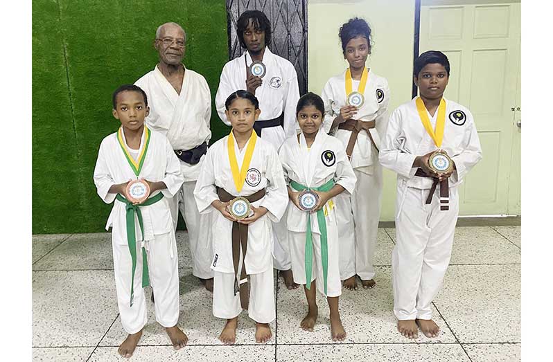 Sensei Winston Dunbar poses with the successful karatekas at the Banks DIH Sports Club on Tuesday