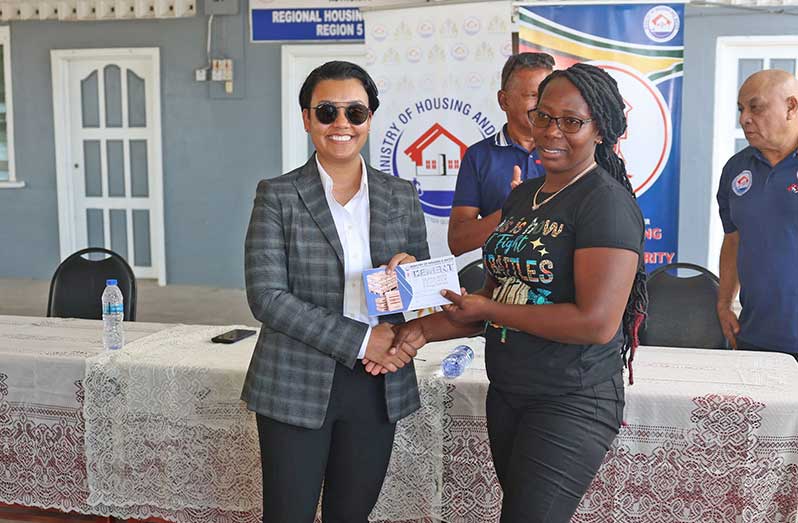 Ministry of Housing and Water’s Susan Rodrigues hand over the Steel and Cement Housing Subsidy vouchers, valued at $225,000, to one of the recipients at the Regional Housing Office in Fort Wellington