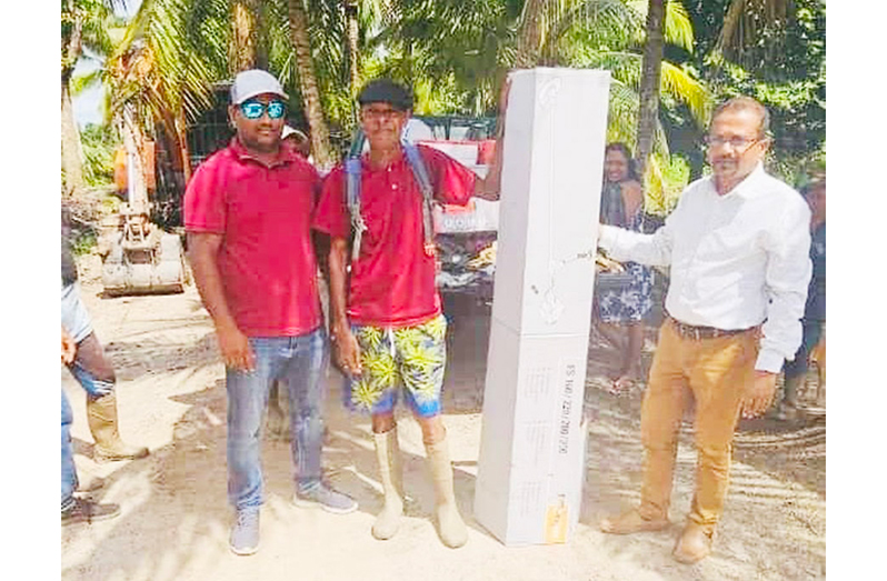 Region Two Vice-Chairman Humace Oodit hands over a farming tool to a farmer