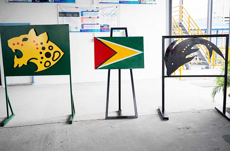 Steel cuts done by the local fabricators, ZECO Group of Services Inc (the flag)., Industrial Fabrications Inc. (InFab) (the jaguar) and Guyana Oil and Gas Support Services Inc. (GOGSSI) (the fish) being displayed at the Jaguar FPSO Steel Strike Ceremony