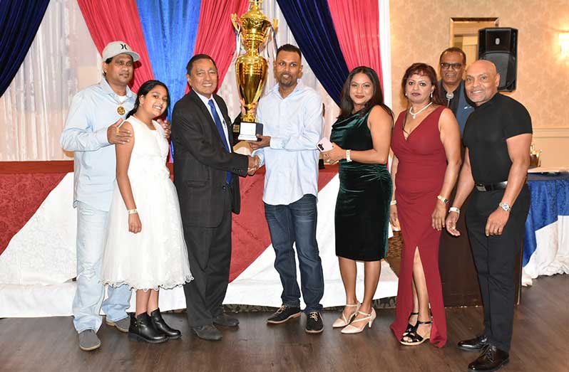 Canadian Legends skipper Sudesh Beharry collects the winning Over-40 Division trophy from OMSCC President Azeem Khan.