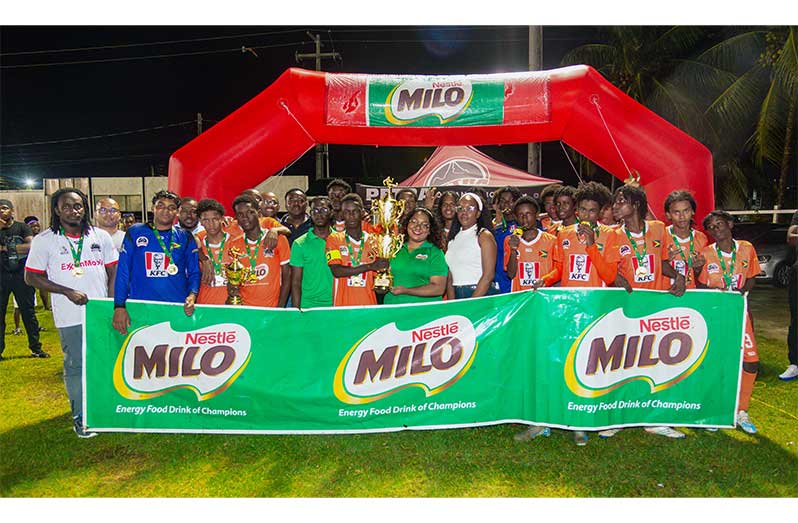 Dolphin Secondary players celebrate with the trophy after their title win