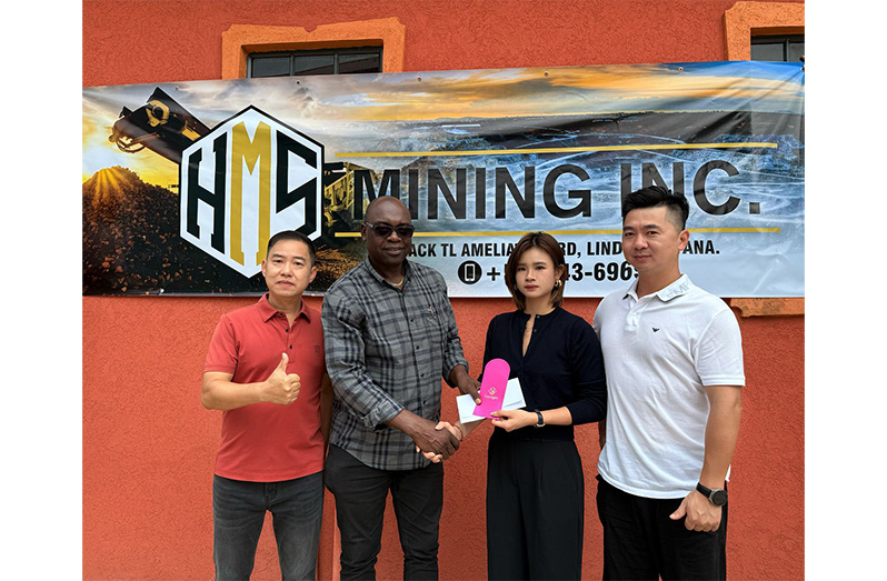 HMS Mining Inc. Executive Secretary, Di-Yi Lin hands over a cheque to Aubrey ‘Shanghai’ Major in the presence of Managing Directors, Hualeng Liang and Jie Lin