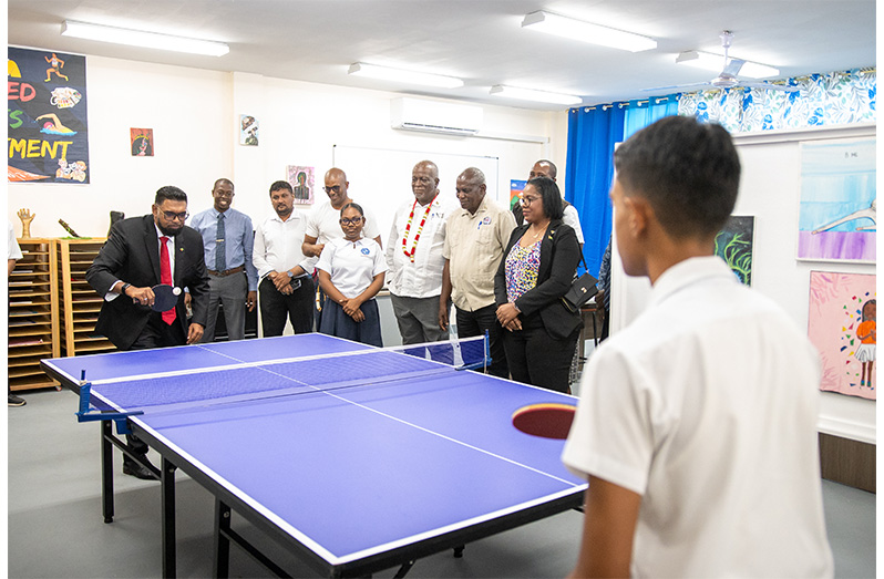 President Ali takes a break from a tour of the newly-commissioned Christ Church Secondary to play a game of table tennis with a student who surely tested his talent (Delano Williams photo)