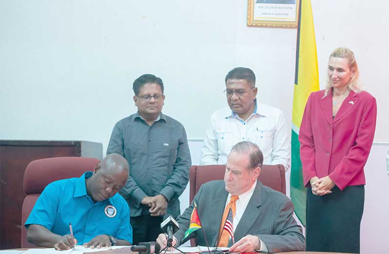 Seated is a representative of Guyana’s Agriculture Ministry and Blumberg Grain’s Chairman, Philip Blumberg, signing the official documents on Wednesday morning, as Finance Minister, Dr. Ashni Singh, Agriculture Minister, Zulfikar Mustapha and U.S. Ambassador to Guyana, Nicole Theriot look on (Delano Williams photo)