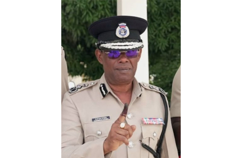 Commissioner of Police Clifton Hicken displays his inked right index finger after casting his ballot