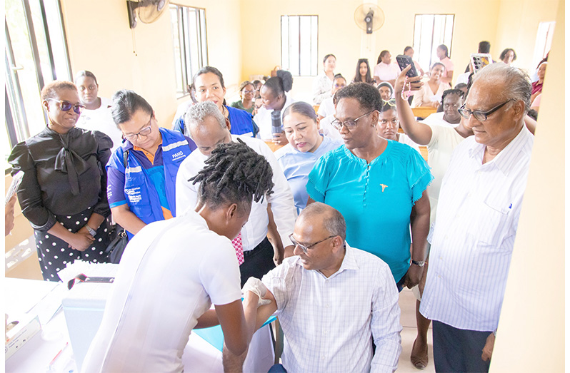 A nurse administers the flu vaccine to Health Minister Dr. Frank Anthony at the launch of Guyana’s first national influenza vaccination campaign, held at the Eccles Health Centre