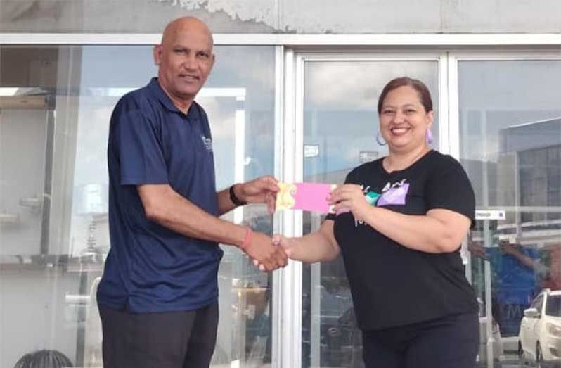 Managing Director of Regal Stationery & Computer Centre, Mahendra Anil Hardyal receives sponsorship cheque from Dayris Arauz of HL Latinoamerica Furnishings, Panama