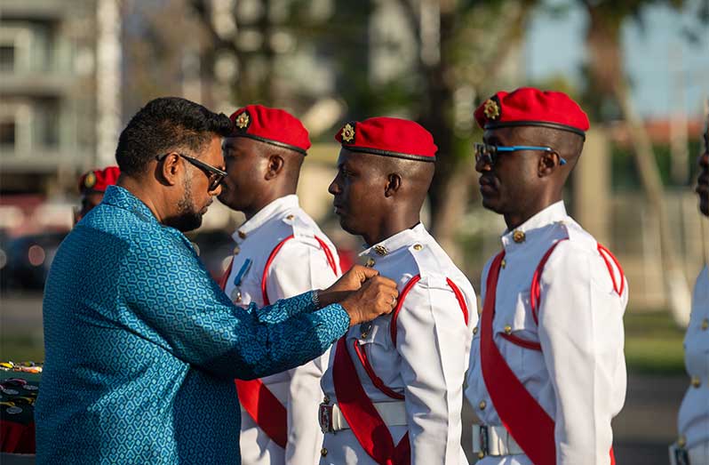 President Dr Irfaan Ali presenting a rank with his medal (Delano Williams photos)