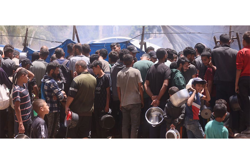 People gather at a food distribution site in Gaza (UN News photo)