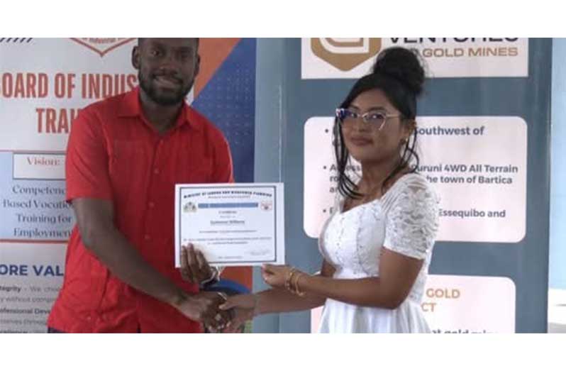 One of the graduates collects her certificate from Minister of Labour and Manpower Planning, Keoma Griffith (DPI photos)
