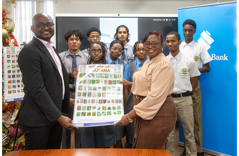 Students from St. Stanislaus College and Brickdam Secondary, Dr Kofi Dalrymple, Presidential Adviser to the Ministry of Education receive the charts from Jonelle Dummett, Manager - Marketing & Communications, Republic Bank (Guyana) Limited