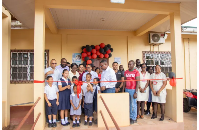 Minister of Health Dr. Frank Anthony, along with residents and staff participating in the ribbon cutting
