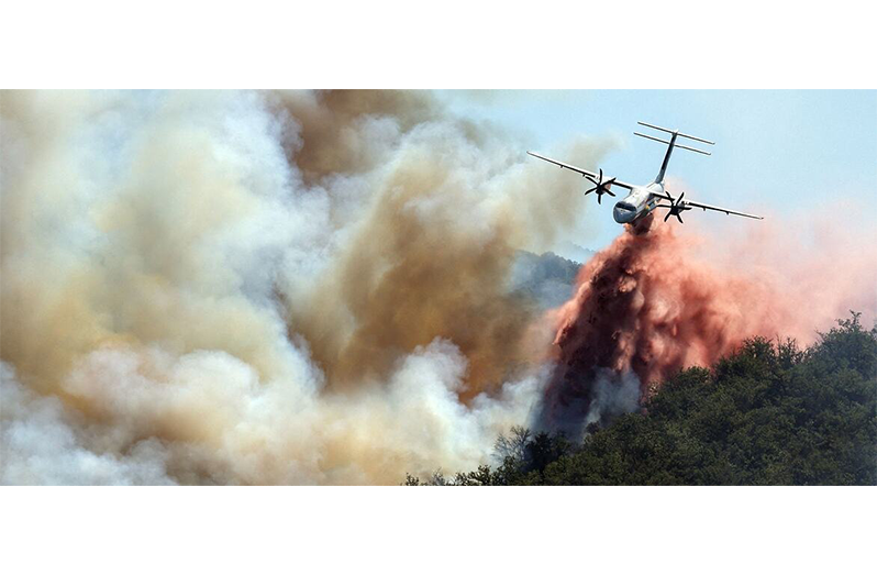 A firefighting plane drops water on a wildfire in France (Adobe Stock/Arafat)