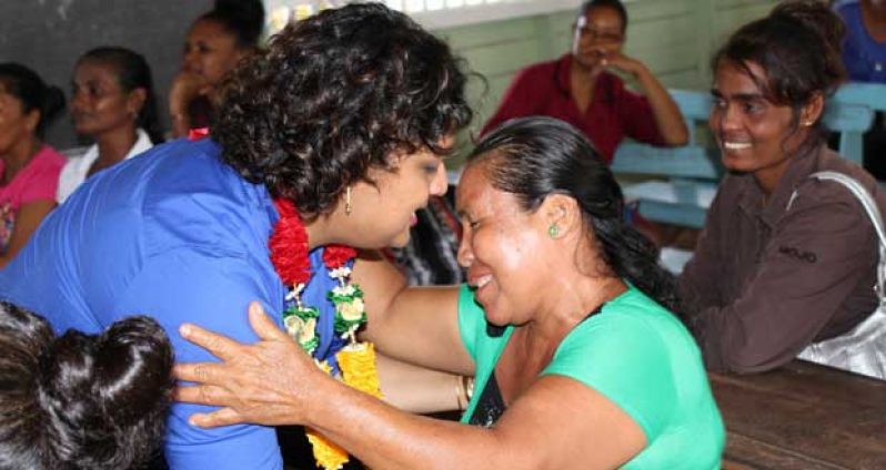 Minister of Education Priya Manickchand reaching to embrace a parent of the Aurora Primary School.