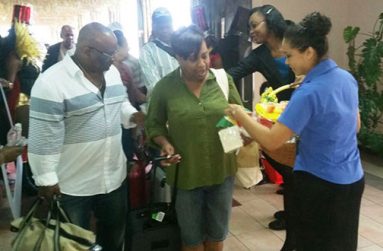 Staff distributing samples to arriving visitors at CJIA
