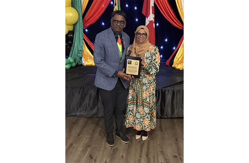 Narine Dat Sookram collects his award from Bibi Shariman Ali, mother of Guyana’s President, Dr Irfaan Ali