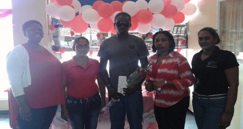 One of the winners, Rondhill Wilson, in the GTPAK Valentine’s Day promotion (centre) is flanked by officials of Laparkan
