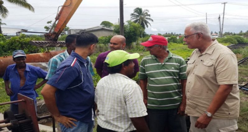 Minister Noel Holder (extreme right) speaking to some farmers during his visit yesterday