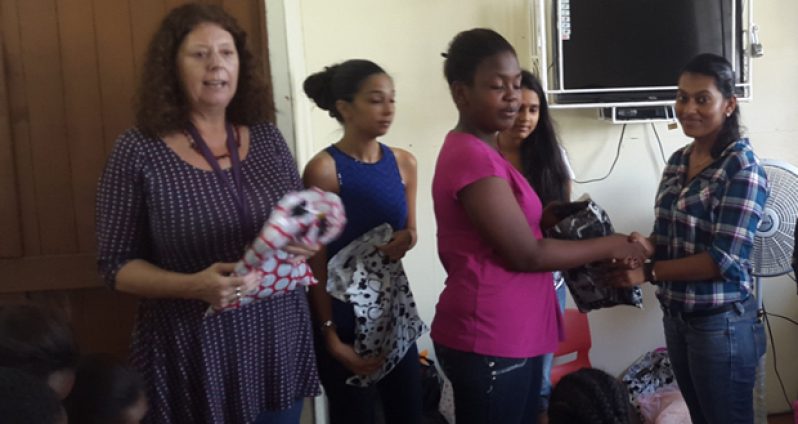 Maria Mursalin handing over gifts donated by the Social Work students to the Ruimveldt Children’s Aid Centre