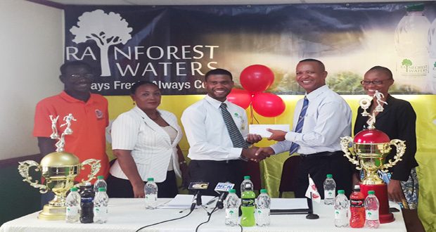 Banks DIH’s Errol Nelson makes the presentation to AAG president Aubrey Hutson at yesterday’s launch.