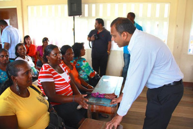 Culture & Sport Minister, Dr. Frank Anthony speaks with parents on the distribution process