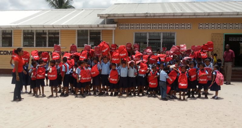 Pupils and teachers of the St. Cuthbert’s Primary School outside their school building on Thursday after they received their gifts from Digicel Guyana