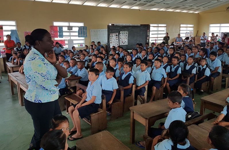 Minister Henry addressing students of a regional primary school