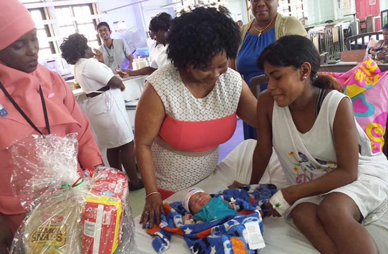 Minister Volda Lawrence admires this little cutie while on a visit to the Maternity Ward of the GPHC to distribute hampers on Mother’s Day (Eclipse Digital photo)