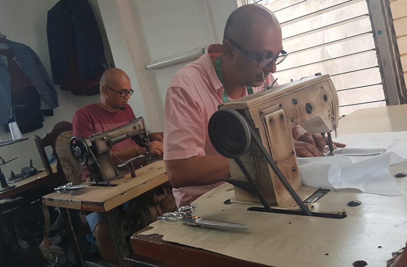 The Ramnarine brothers at work in their tailor shop at Alexander Street, Kitty