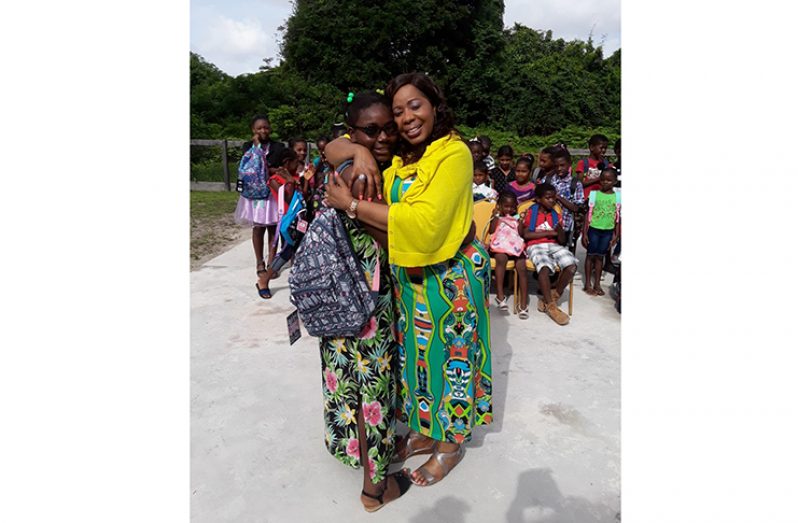 Guyanese-born humanitarian Angela Grant, of the Angela Grant Foundation, embraces one of the many children who benefitted from a donation of school supplies in Queenstown, Essequibo