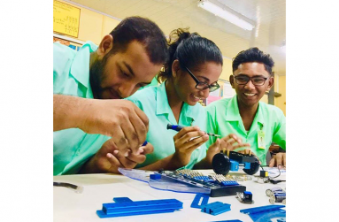 Students of the New Amsterdam Technical Institute (NATI) assemble a robotics kit.