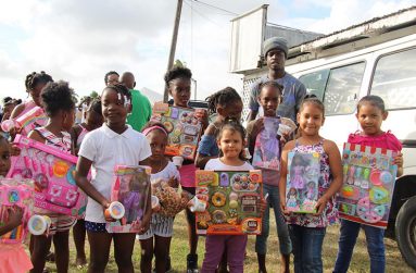 Children pose with their Christmas presents at a Christmas party hosted by Minister of Social Protection, Ms. Amna Ally for the children of Georgetown.