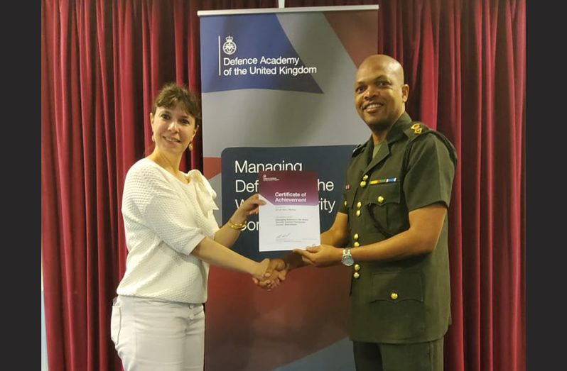 Lieutenant-Colonel Eon Murray receives his certificate of achievement from a representative of the UK Defence Academy