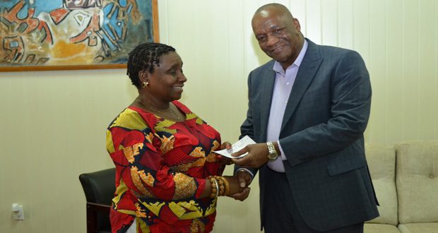 Minister of State Joseph Harmon handing over the cheque to ACDA volunteer Gail Napoleon, yesterday (Jules Gibson photo)