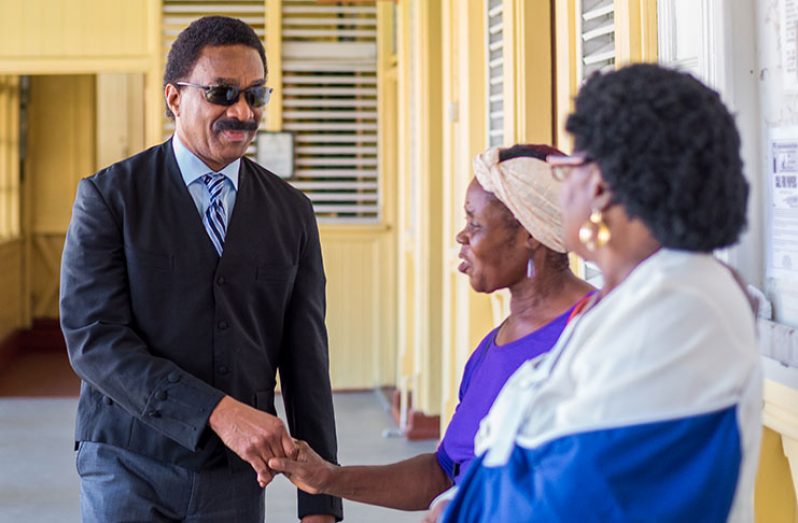 Attorney General Basil Williams greeting two government supporters in the corridor of the High Court shortly before entering the courtroom on Wednesday. 
Delano Williams’ Photo