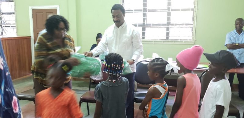 Attorney-General and Minister of Legal Affairs, Basil Williams SC, presenting the “David G” branded backpacks to primary school students in the East Coast Demerara corridor.