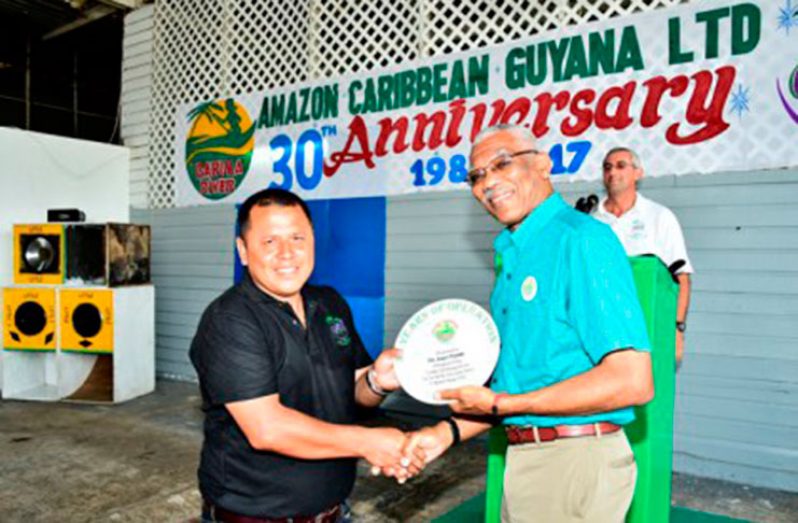 President David Granger presenting a special token to one of AMCAR’s staff members, Mr. Andy Pierre, for his long and dedicated service to the company