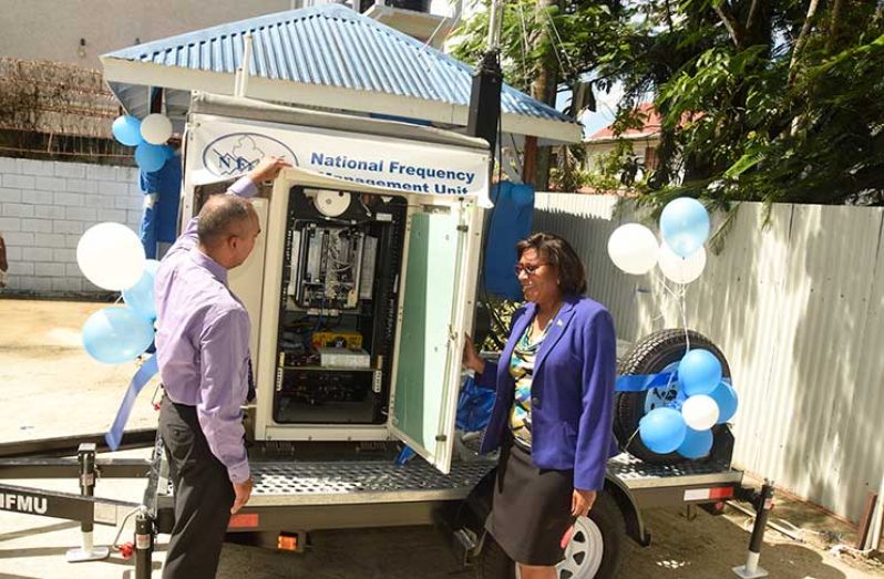 Public Telecommunications Minister, Cathy Hughes and NFMU Managing Director, Valmikki Singh, examine the transportable spectrum monitoring station during the commissioning of the equipment at NFMU, Wednesday.