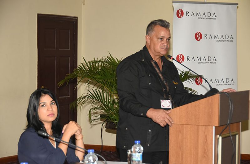 Captain Gerry Gouveia speaking to members of the gathering as businesswoman, Simone San-Ghuran, looks on.