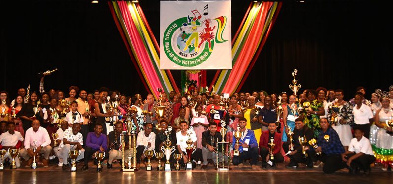 Winners in the Mash 2018 competitions proudly display their trophies while posing with Dr. George Norton and other functionaries at the Prize Giving Ceremony at the National Cultural Centre on Friday evening.