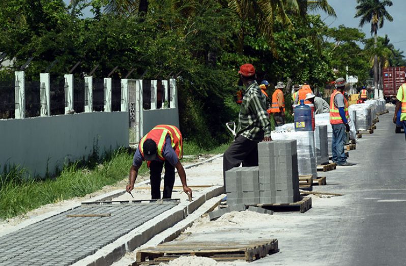 Workers busy at work. The pavement (walkway) along Woolford Avenue, Georgetown under construction