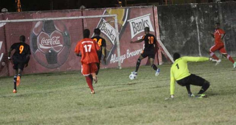 A beaten Boys’ Town keeper Kirk Porter (#1), watches as Slingerz Football Club’s Anthony ‘Awo’ Abrams (#20) sets up to score the opening goal of the game. (Sonell Nelson photo)
