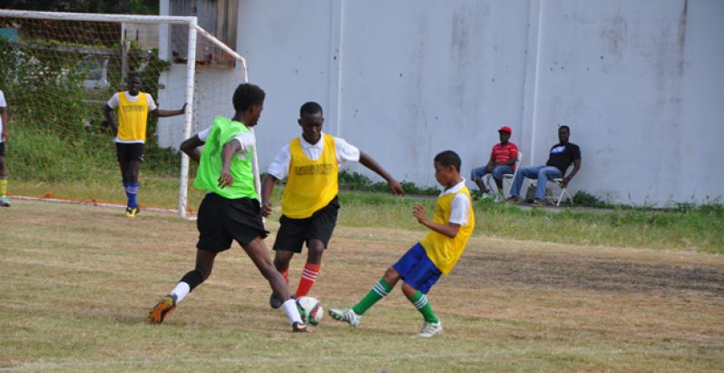 Part of the action between Richard Ishmael and Carmel Secondary at the Ministry of Education Ground yesterday.