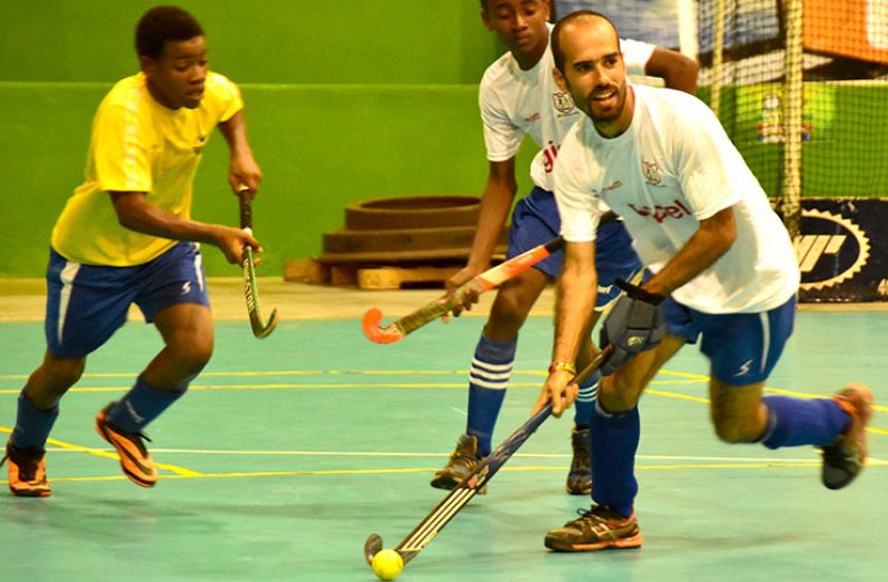 Robert Fernandes carries the ball during Tuesday night’s action in the GTT National Indoor Hockey Championship. (Adrian Narine Photo)